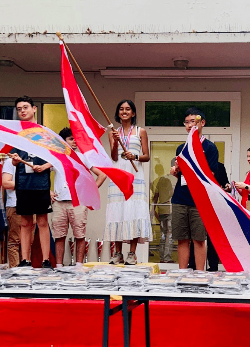 Waving the Canadian flag, standing at the top of a podium